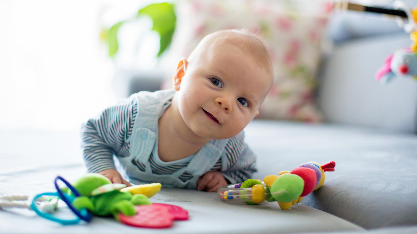 Mit Spielzeug können Eltern das Baby dazu bewegen, sich herumzurollen und damit einen ersten Schritt zur eigenen Mobilität zu tun.