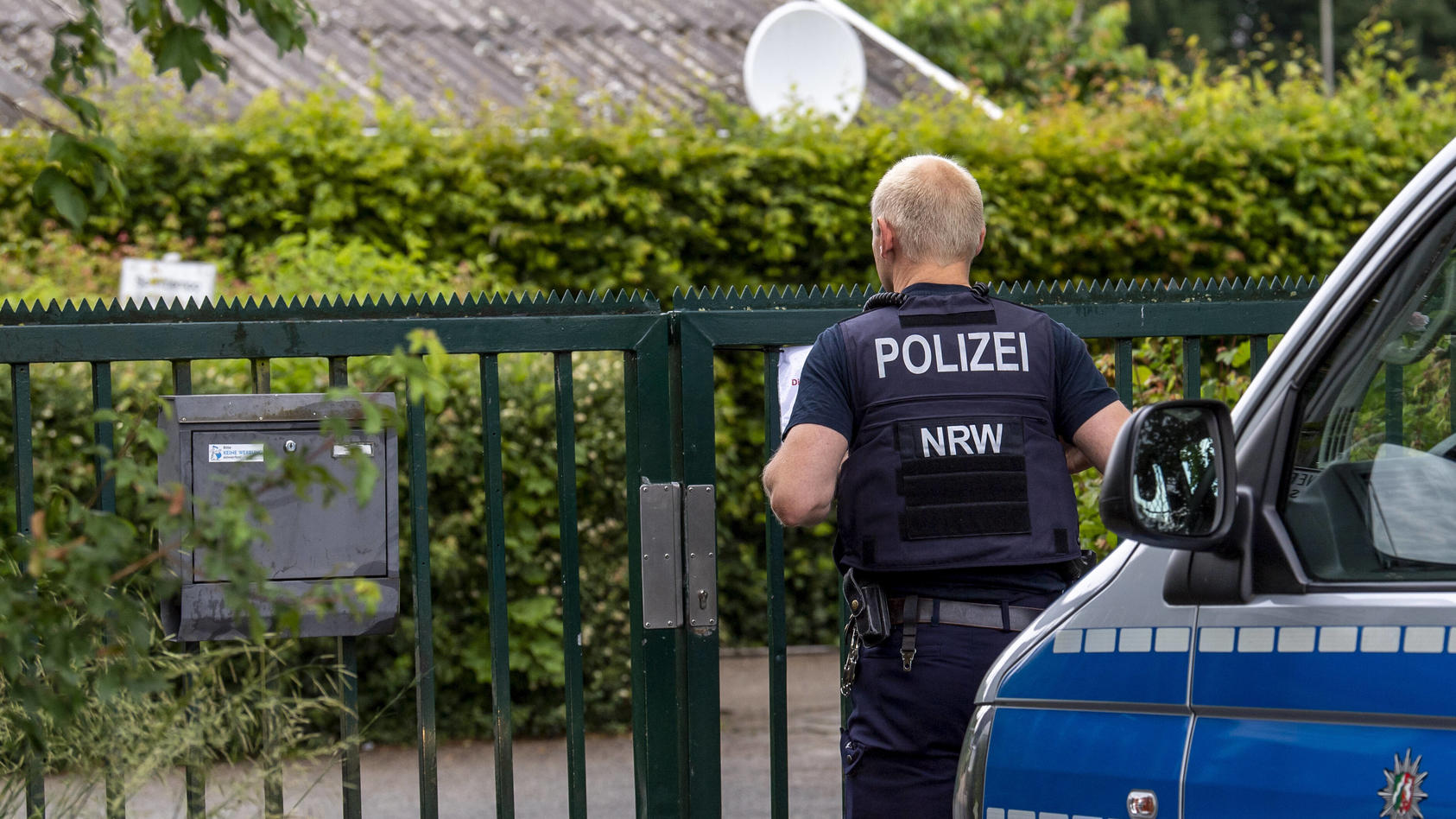 Kindermissbrauch in Münster Gesellschaft: Verbrechen, Prozesse. Ein Polizist steht am Eingang der Kleingartenanlage in M