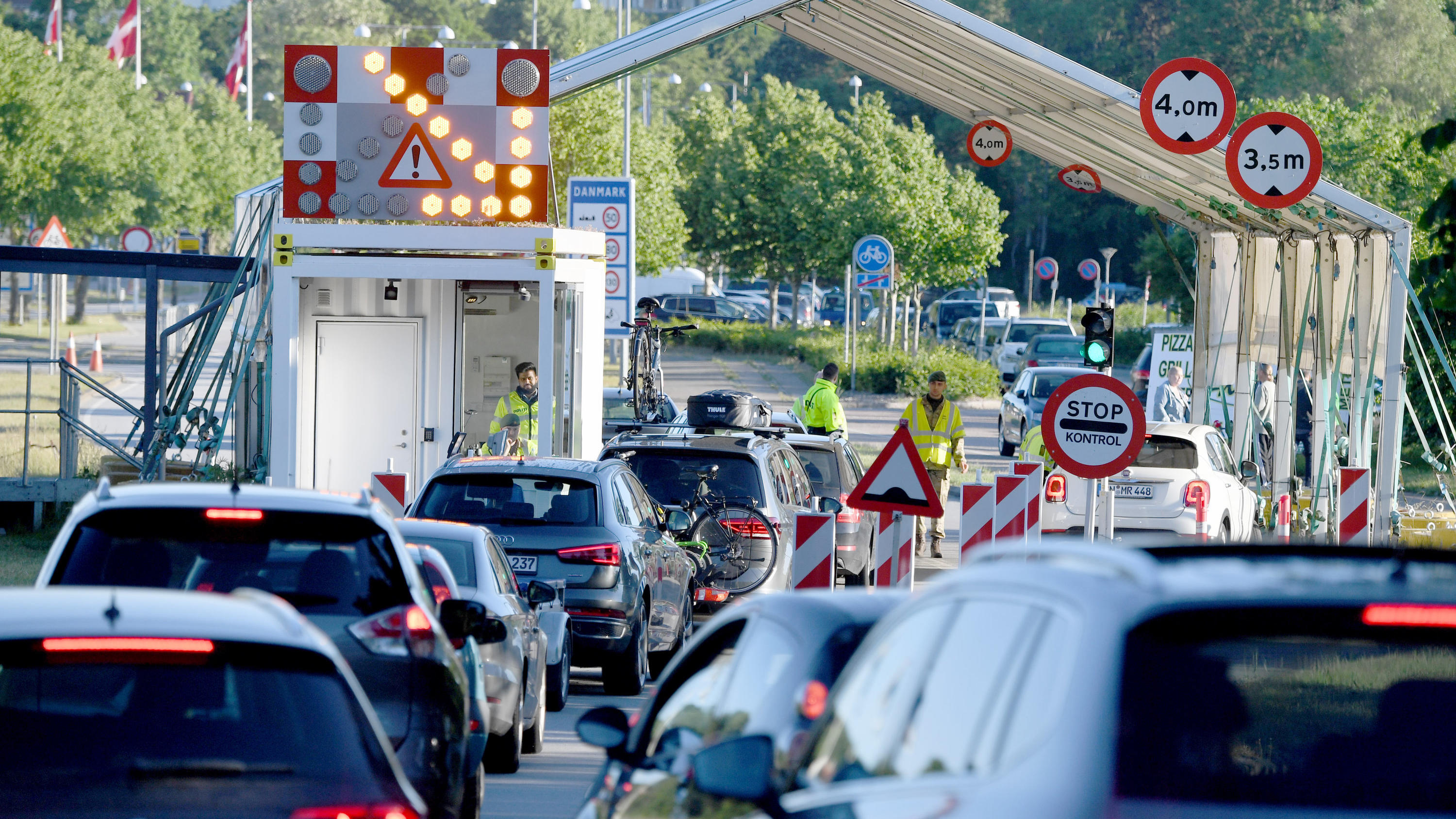 dpatopbilder - 15.06.2020, Schleswig-Holstein, Flensburg: Autos stehen am Grenzübergang Krusau in Richtung Dänemark. Deutsche Touristen dürfen seit Mitternacht wieder nach Dänemark einreisen. Voraussetzung dafür ist jedoch, dass sie mindestens sechs 