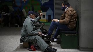 16.06.2020, Kolumbien, Bogota: Ein Schuhputzer spricht mit einem Kunden, nachdem die Anti-Corona-Maßnahmen in der Hauptstadt weiter gelockert wurden. Das südamerikanische Land hat 53.063 Covid-19-Infizierte und 1.726 Coronavirus-Todesopfer bestätigt. Foto: Sergio Acero/colprensa/dpa +++ dpa-Bildfunk +++