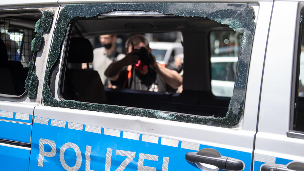 22.06.2020, Baden-Württemberg, Stuttgart: Ein während der nächtlichen Randale in Stuttgart beschädigtes Polizeiauto, das zuvor für einen Ortsbesuch von Bundesinnenminister Seehofer an den Ort der Randale gebracht worden war, wird von einem Fotografen