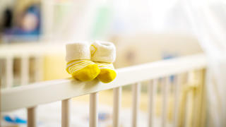 Leeres Babybett mit Socken