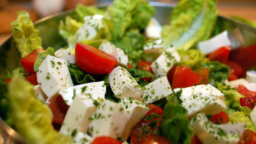 Salat mit Tomaten und Mozzarella angerichtet in einer Salatschüssel.