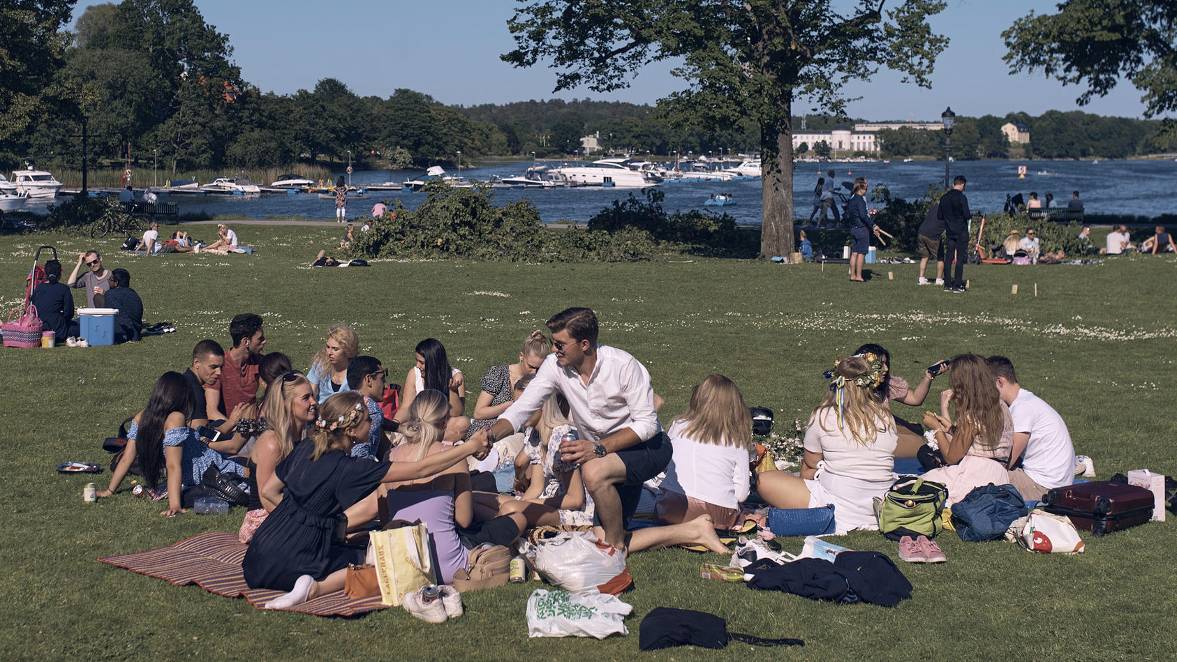 19.06.2020, Schweden, Stockholm: Eine Gruppe junger Menschen picknickt während der jährlichen Mittsommerfeierlichkeiten Schweden und Finnen haben ihr diesjähriges Mittsommer-Fest eingeleitet. Wegen der Corona-Pandemie mussten viele größere Veranstalt