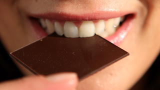ARCHIV - ILLUSTRATION - Eine junge Frau beißt am 29.01.2010 in Köln in ein Stück Schokolade. Gute Nachrichten für alle Schokoladenliebhaber: Wer viel Kakaoprodukte isst, leidet deutlich seltener an gefährlichen Herz- und Gefäßerkrankungen. Nach einer britischen Studie haben Menschen mit hohem Schokoladenkonsum ein um 37 Prozent niedrigeres Risiko einen Herzinfarkt oder eine andere Herz-Kreislauf-Erkrankung zu bekommen als diejenigen mit sehr niedrigem. Das Schlaganfallrisiko liegt um 29 Prozent niedriger. Foto: Oliver Berg dpa  +++(c) dpa - Bildfunk+++