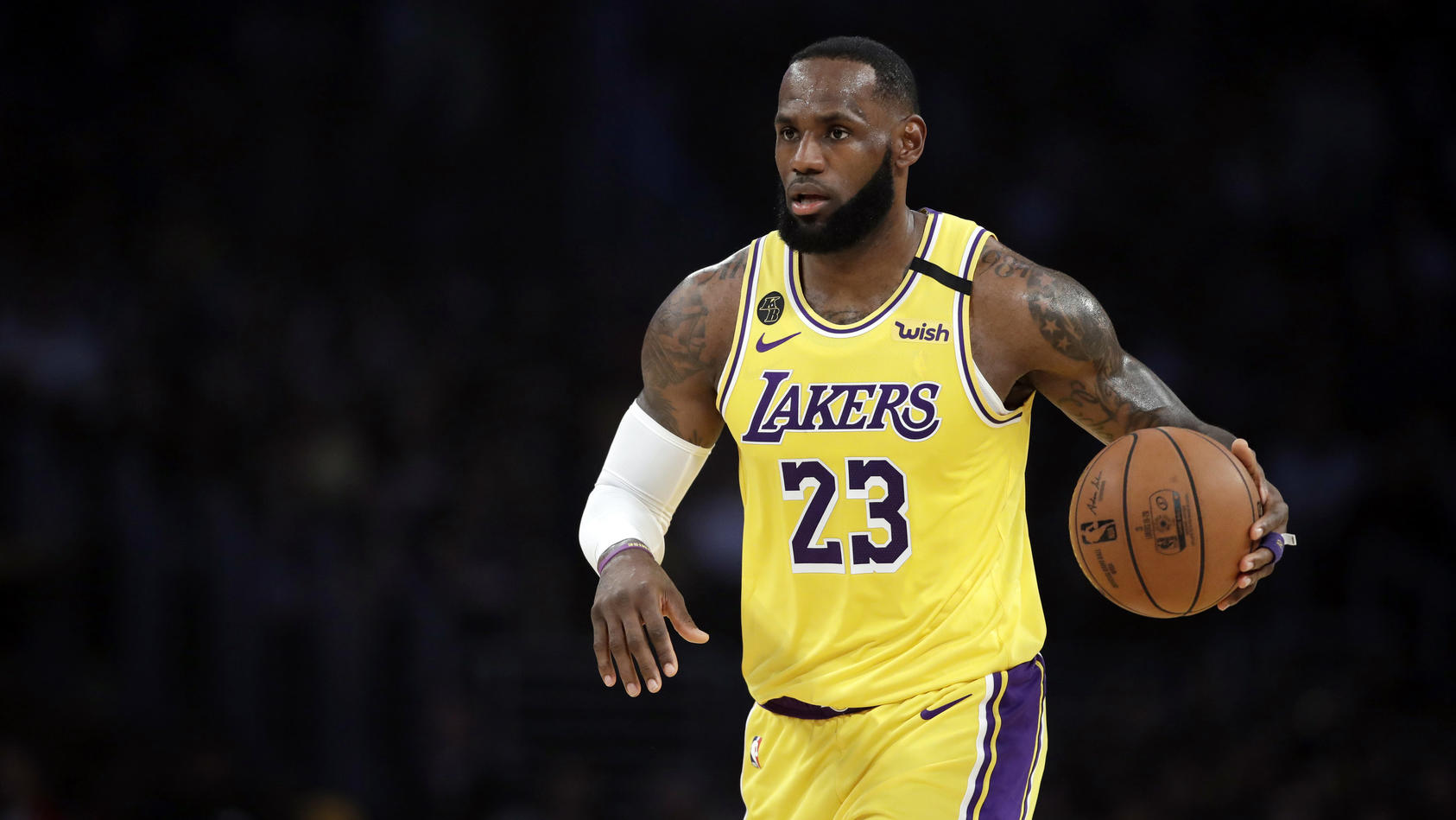 FILE - In this March 10, 2020, file photo, Los Angeles Lakers' LeBron James (23) dribbles during the first half of an NBA basketball game against the Brooklyn Nets in Los Angeles. If James gets his way, NBA arenas and other sports venues around the c