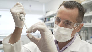 In this image from video provided by Washington University, researcher Nicolas Barthelemy works on a p-tau217 test for Alzheimer's disease at a laboratory in St. Louis, Mo., on Monday, July 27, 2020. Several companies and universities have developed versions of these tests, which look for a form of tau protein, one of the substances that can build up and damage the brains of people with Alzheimerâ€™s. (Huy Mach/University of Washington via AP)