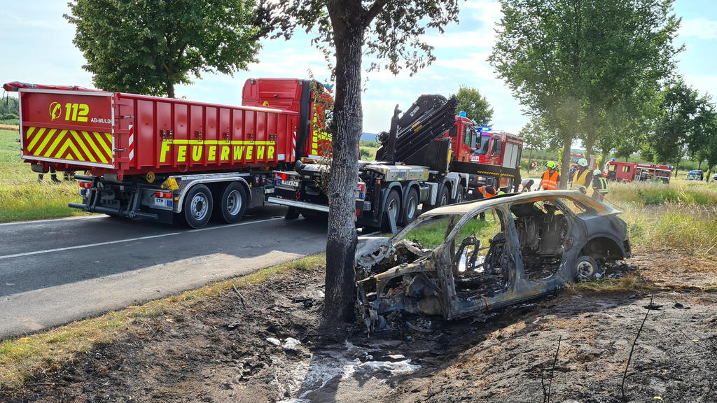 28.07.2020, Brandenburg, Groß Kreutz: Das ausgebrannte Unfallwrack eines Autos steht an einem Baum. Eine junge Fahrerin ist in Groß Kreutz bei Potsdam mit dem Auto gegen einen Baum geprallt und darin verbrannt. Es sei schwierig gewesen, die Frau in d
