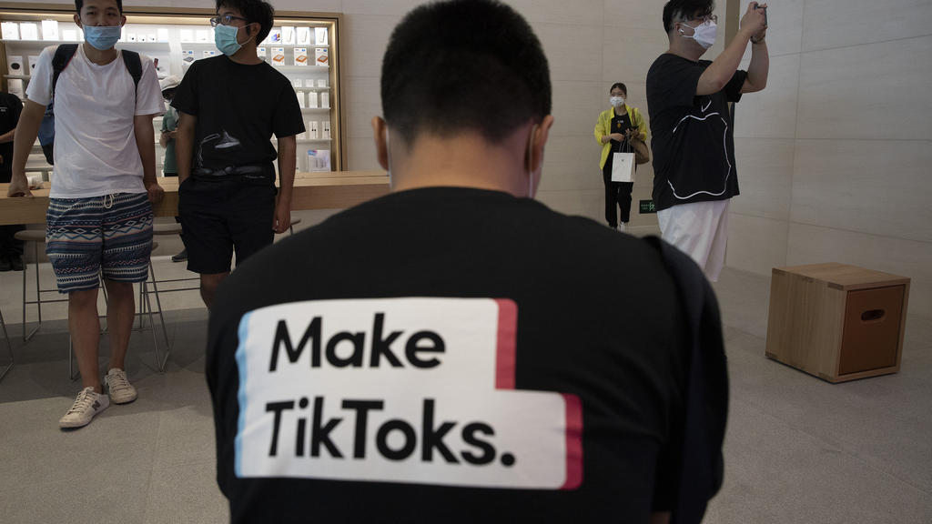 A man wearing a shirt promoting TikTok is seen at an Apple store in Beijing on Friday, July 17, 2020. U. S. President Donald Trump says he wants to take action to ban TikTok, a popular Chinese-owned video app that has been a source of national securi