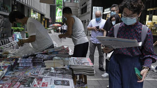 People queue up at a news stand to buy copies of Apple Daily at a downtown street in Hong Kong Tuesday, Aug. 11, 2020, as a show of support, a day after the arrest of its founder Jimmy Lai. Hong Kong authorities arrested media tycoon Jimmy Lai on Monday, broadening their enforcement of a new national security law and stoking fears of a crackdown on the semi-autonomous region's free press.(AP Photo/Vincent Yu)