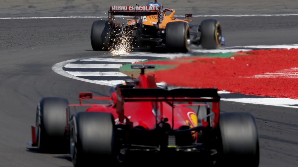 Mclaren driver Carlos Sainz of Spain, top, and Ferrari driver Sebastian Vettel of Germany steer their cars during the 70th Anniversary Formula One Grand Prix at the Silverstone circuit, Silverstone, England, Sunday, Aug. 9, 2020. (AP Photo/Frank Augs