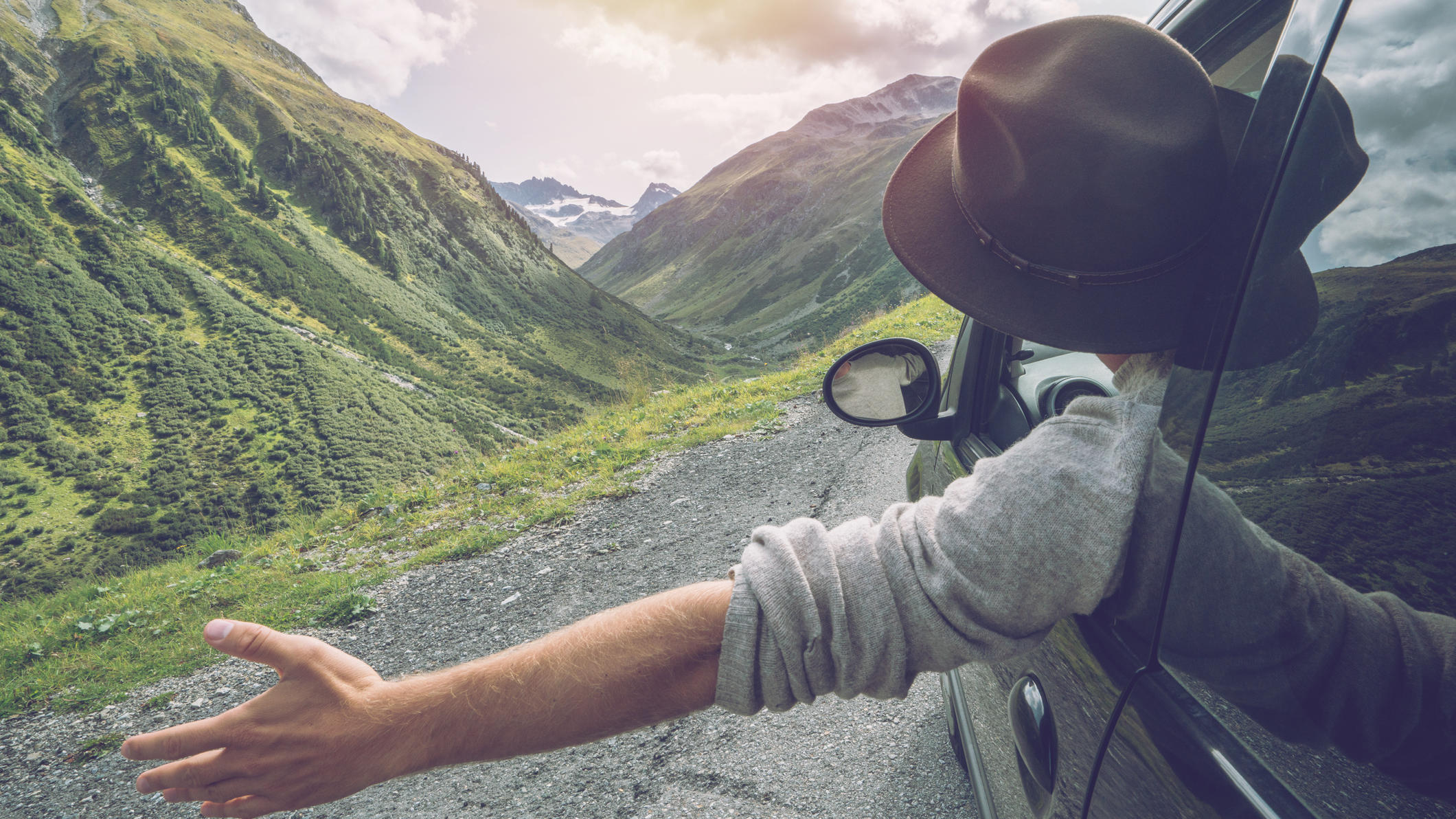 Reiselust: Mann schaut aus Auto auf die Berge