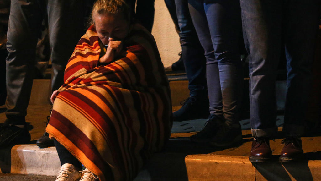 MINSK, BELARUS - AUGUST 14, 2020: A woman sits on a kerb while detained protesters leave a temporary detention facility. Following the announcement of the election results on 9 August, mass protests erupted in major cities across Belarus, escalating