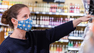 Frau mit Stoffmaske im Supermarkt