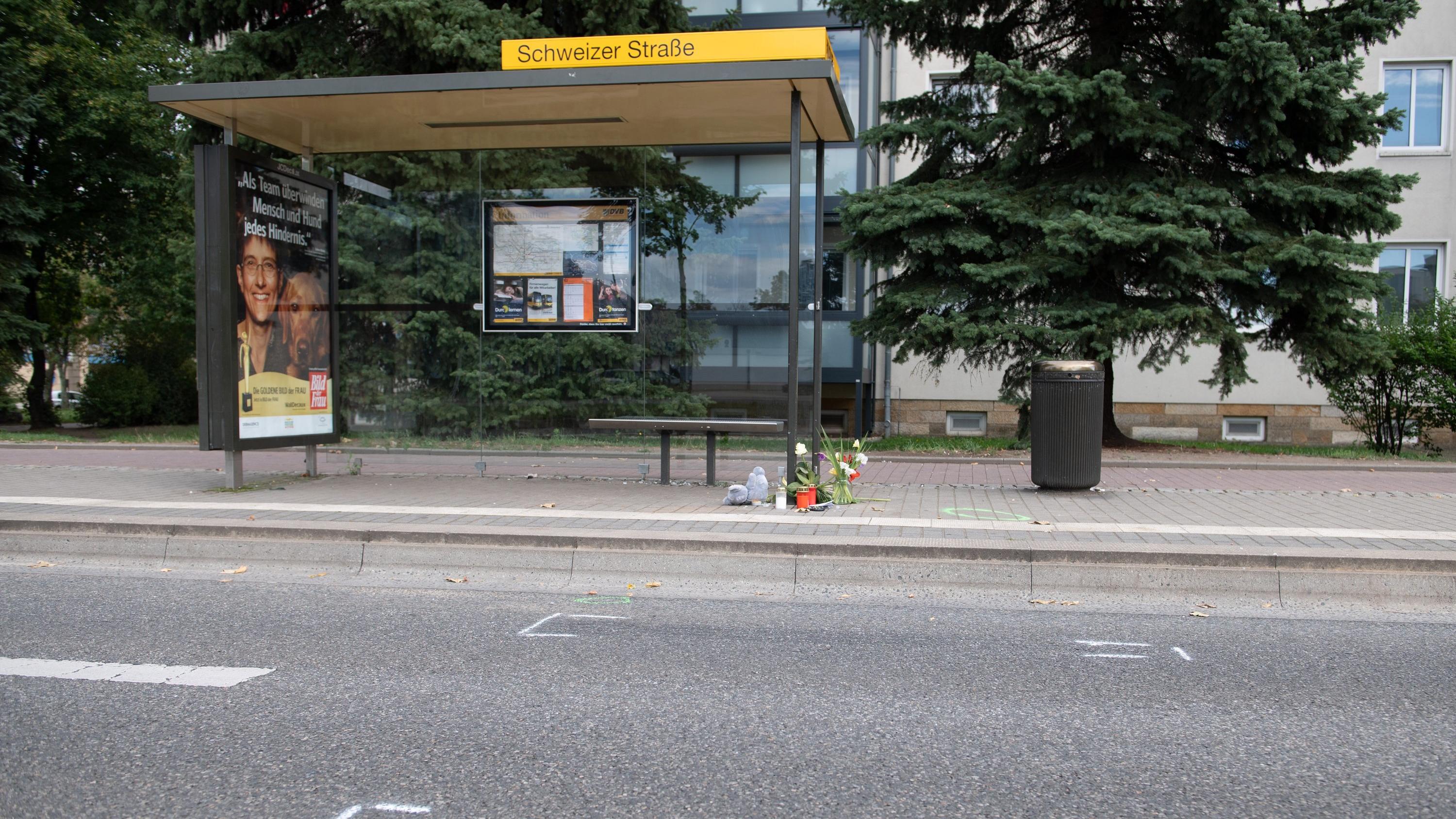23.08.2020, Sachsen, Dresden: Ein Plüschtier und Blumen liegen nach einem Verkehrsunfall an einer Bushaltestelle. Ein sechsjähriger Junge ist bei einem Unfall am Abend des 22. August 2020 gestorben · womöglich weil sich zwei Männer ein illegales Auto