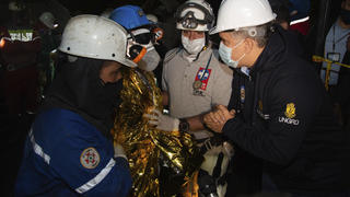 In this photo released by Colombia's Presidential Press Office, Colombia's President Ivan Duque, right, welcomes one of the three miners that were rescued after 5 days of being trapped in a mine that collapsed in Lenguazauqe, Colombia, Sunday, Aug. 23, 2020. (Colombia's Presidential Press Office via AP)
