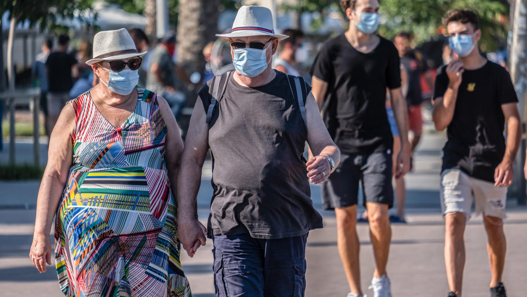 Menschen mit der vorgeschriebenen Hygienemaske in Barcelona