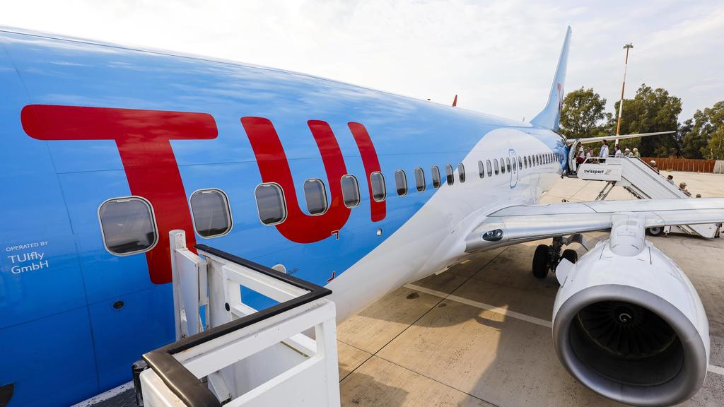 Urlauber besteigen ein TUI-Flugzeug,