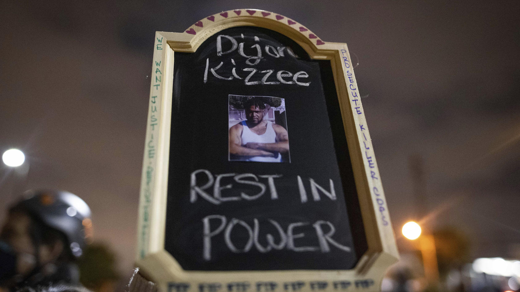 A protester holds a sign with a picture of Dijon Kizzee, who died after being shot by deputies of the Los Angeles Sheriff's Department on Monday, Aug. 31, 2020, in Los Angeles, Calif. (AP Photo/Christian Monterrosa)