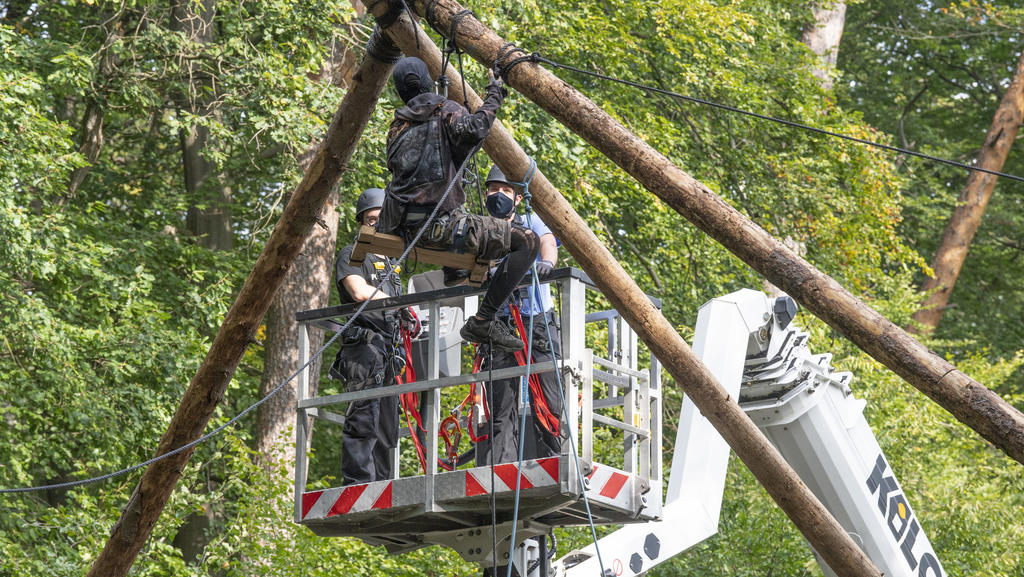 Die Polizei räumt Barrikaden von Waldbesetzern im Dannenröder Forst in Mittelhessen. Eine Aktivistin sitzt auf einer aus Stämmen errichteten Plattform,.