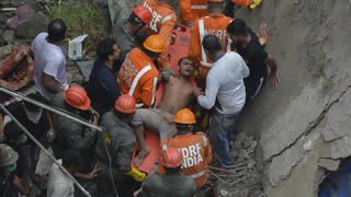 21.09.2020, Indien, Bhiwandi: Mitarbeiter des indischen Katastrophenschutz (NDRF) befreien einen Mann aus den Trümmern eines Wohngebäudes, nachdem dieses in Bhiwandi im Distrikt Thane, einem Vorort von Mumbai, eingestürzt war. Foto: Praful Gangurde/AP/dpa +++ dpa-Bildfunk +++