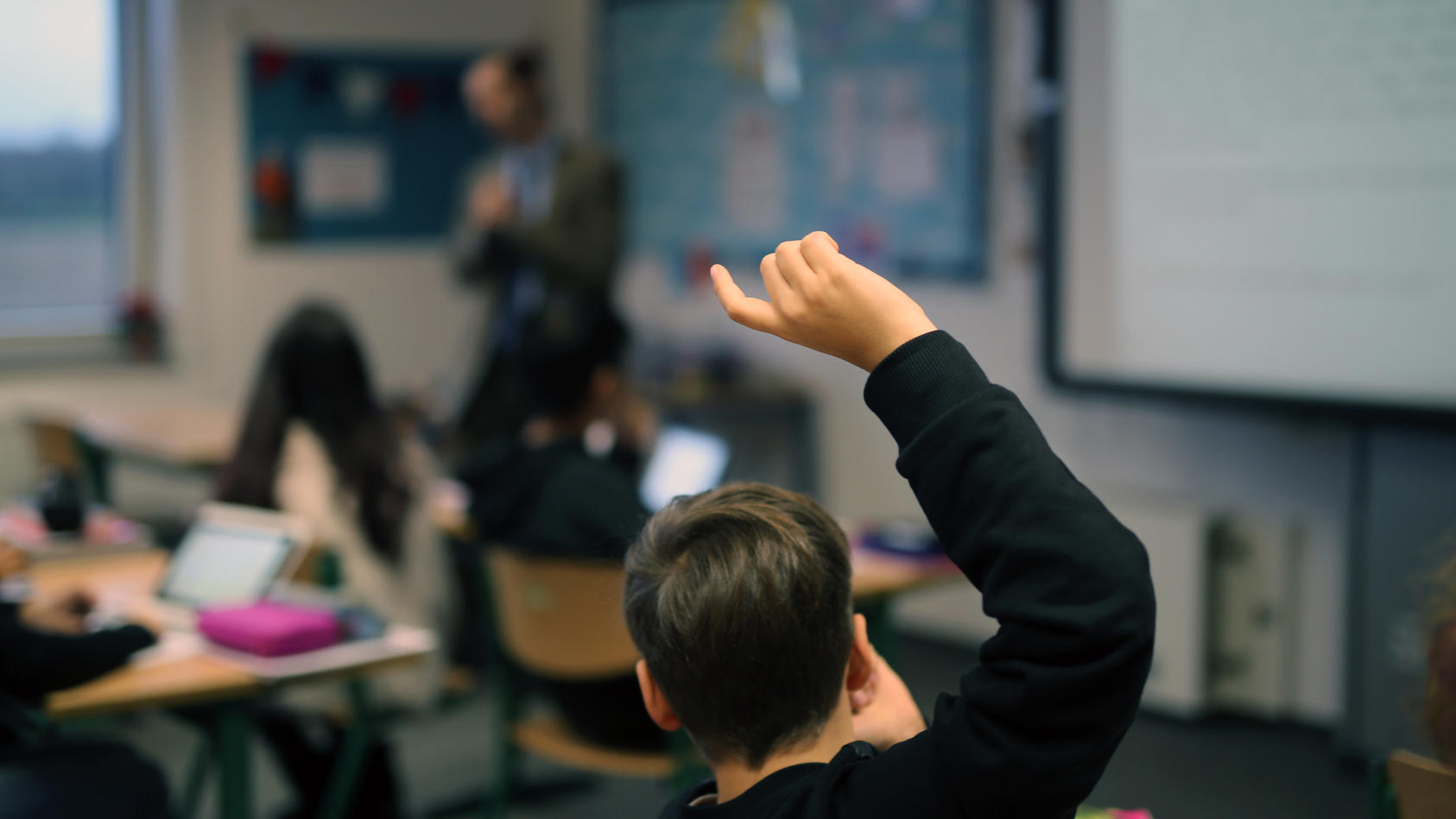 ARCHIV - 15.12.2017, Neuss: Eine Schüler hebt im digitalen Unterricht seine Hand hoch.   (zu dpa «10 000 Lehrer haben sich seit Corona zu Digitaler Schule fortgebildet») Foto: picture alliance / Ina Fassbender/dpa +++ dpa-Bildfunk +++