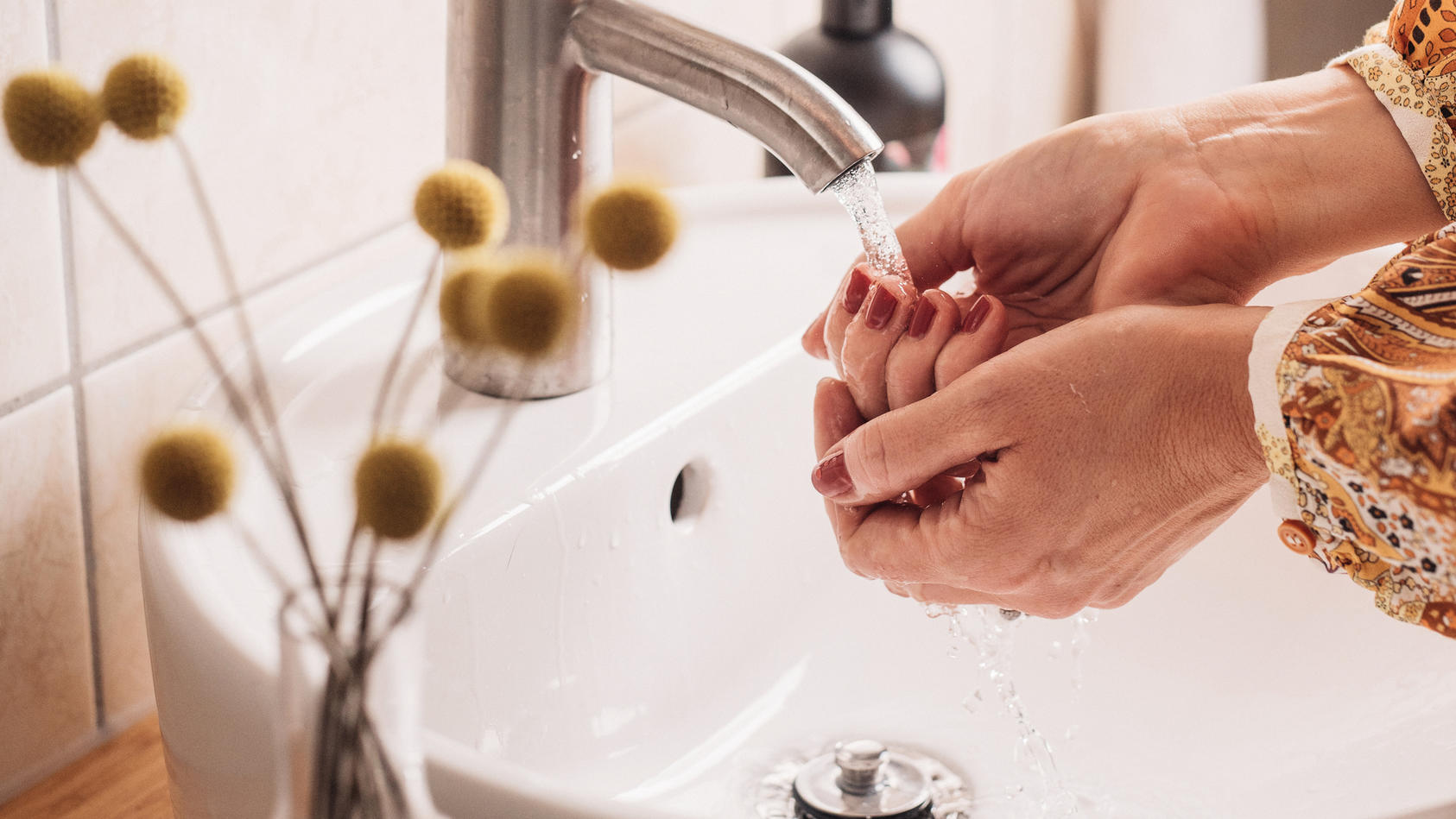 Frau wäscht sich die Hände im Waschbecken