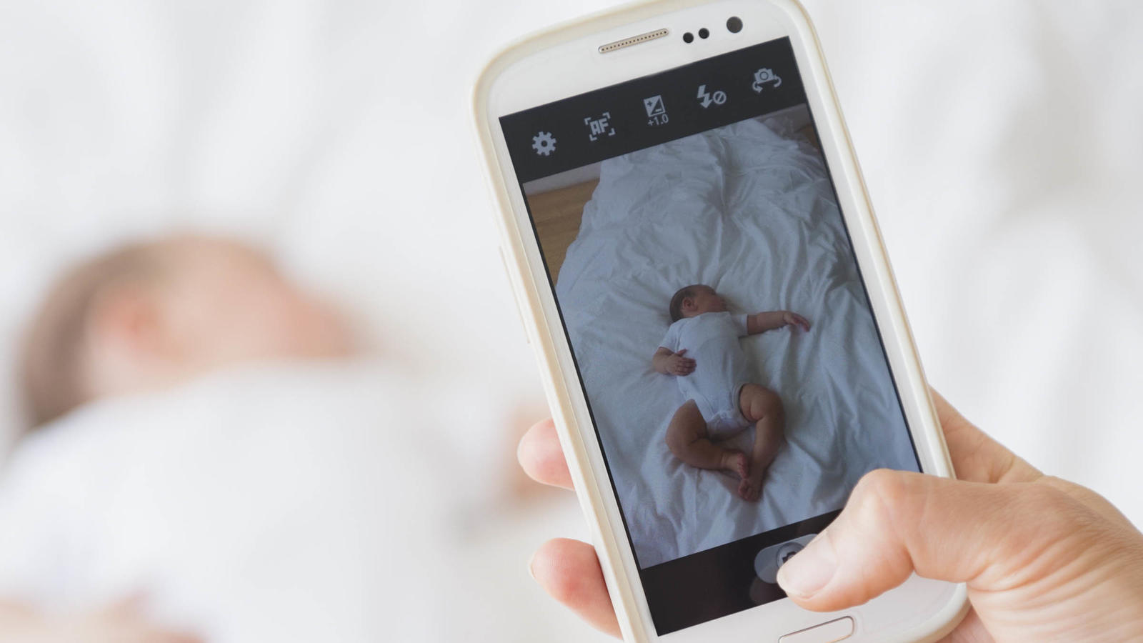 Mother photographing baby girl (2-5 months) sleeping in bed,  , Mutter, die Baby-Maedchen (2-5 Monate) fotografiert, im Bett schlafend | Verwendung weltweit, Keine Weitergabe an Wiederverkäufer.