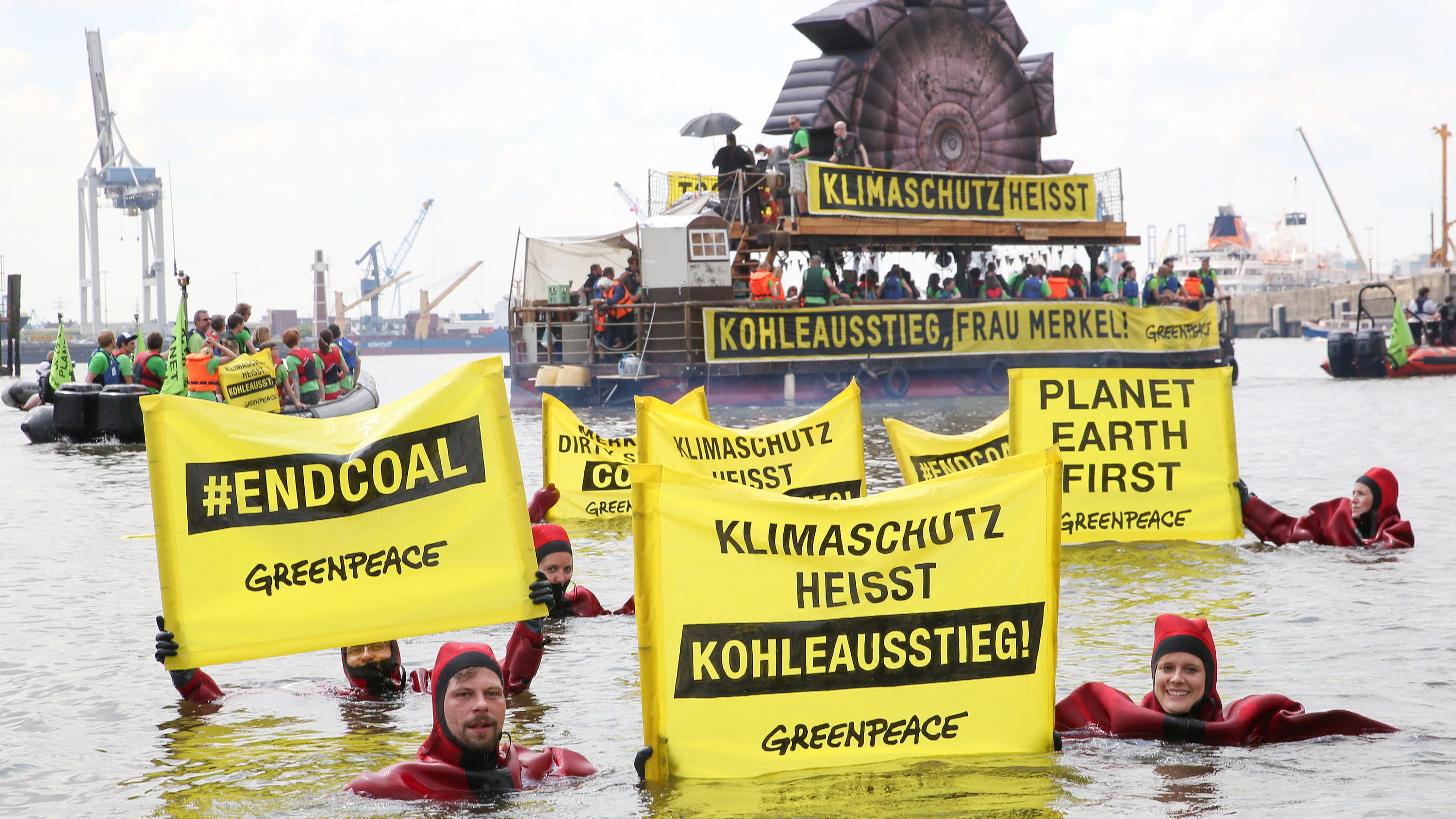 Aktivisten von Greenpeace protestieren am 19.06.2017 in Hamburg in der HafenCity während des C20-Gipfels für den Klimaschutz und gegen die Politik von Bundeskanzlerin Merkel und fahren dabei auf einem Floß mit der Aufschrift «Klimaschutz heisst Kohle