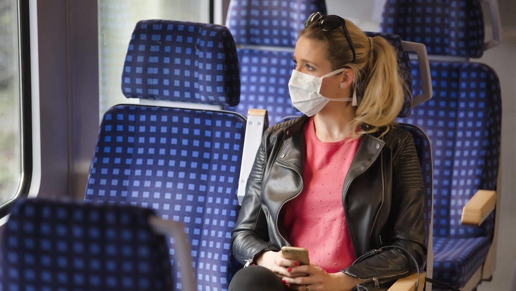 Frau mit Mundschutzmaske, sitzt in Zug, am Handy, Corona-Krise, Stuttgart, Baden-Württemberg, Deutschland Coronavirus *** Woman with a face mask, sitting in Zug, on a mobile phone, corona crisis, Stuttgart, Baden Württemberg, Germany Coronavirus