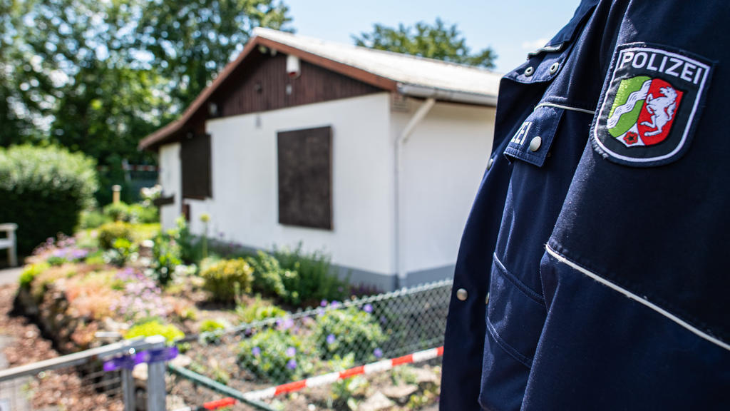 ARCHIV - 06.06.2020, Nordrhein-Westfalen, Münster: Bei den Ermittlungen nach schwerem sexuellem Missbrauch von Kindern steht ein Polizeibeamter vor der Gartenlaube, wo der vermutliche Haupttäter Teile seiner Server-Anlage unterbrachte. Im Fall des sc