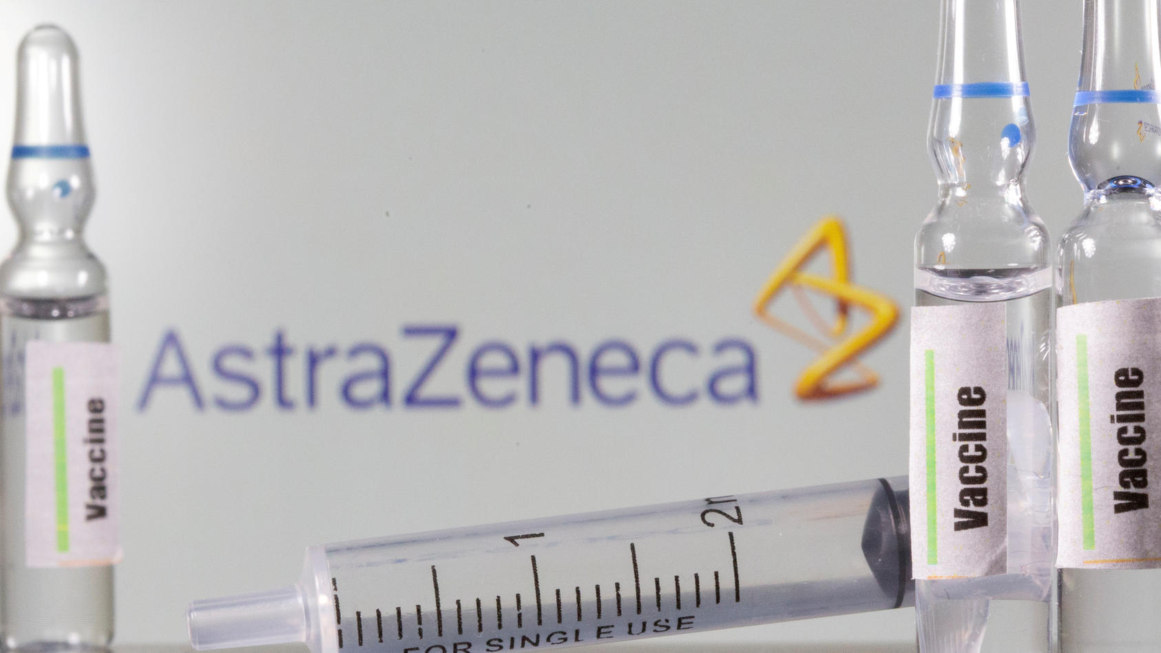 FILE PHOTO: A test tube labelled with the Vaccine is seen in front of AstraZeneca logo in this illustration taken