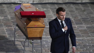 French President Emmanuel Macron leaves after paying his respects by the coffin of slain teacher Samuel Paty in the courtyard of the Sorbonne university during a national memorial event, Wednesday, Oct. 21, 2020 in Paris. French history teacher Samuel Paty was beheaded in Conflans-Sainte-Honorine, northwest of Paris, by a 18-year-old Moscow-born Chechen refugee, who was later shot dead by police. (AP Photo/Francois Mori, Pool)