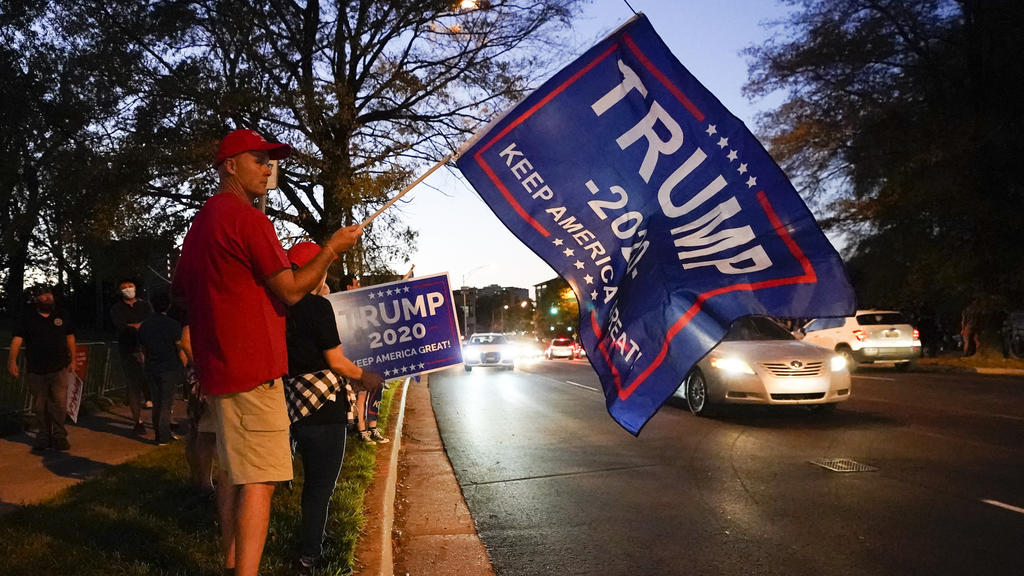 22.10.2020, USA, Nashville: Ein Mann hält im Vorfeld der TV-Debatte vor der Belmont University eine Trump-Fahne. US-Präsident Trump und sein demokratischer Herausforderer Biden treffen vor der Präsidentschaftswahl am 3. November zu ihrem letzten TV-D