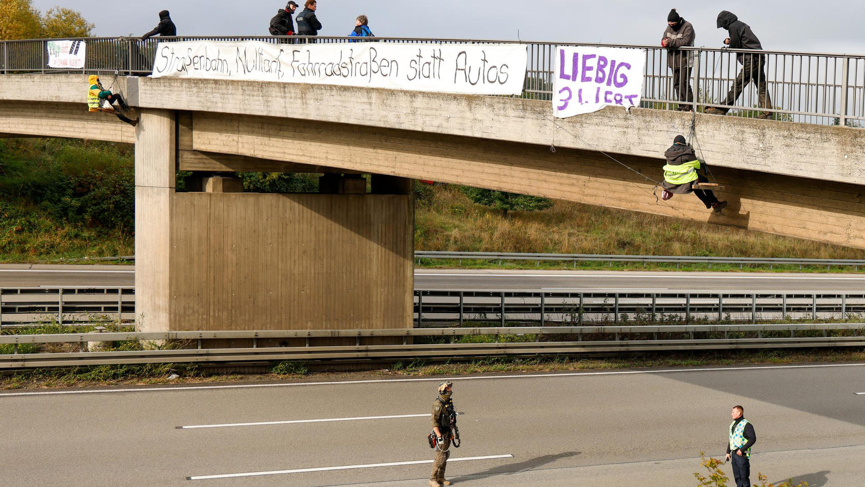 13.10.2020, Hessen, Idstein: Umweltaktivisten hängen an einer Brücke über der Autobahn 3 und protestieren gegen die Rodung von Bäumen im Herrenwald und Dannenröder Forst bei Stadtallendorf im Zusammenhang mit dem geplanten Ausbau der Autobahn 49.  (z