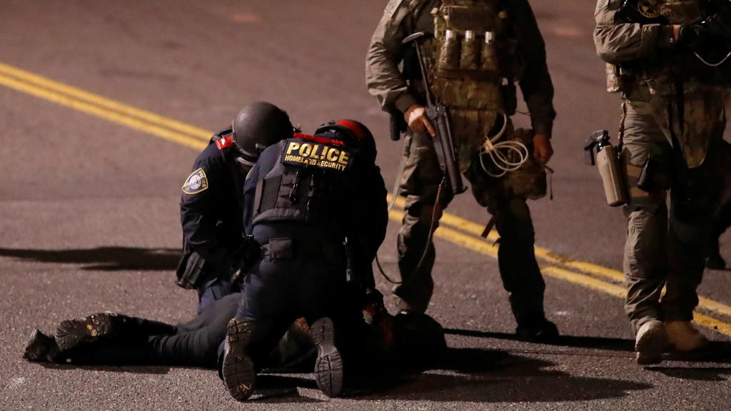 Federal and Portland police detain a demonstrator at an Immigration and Customs Enforcement facility in Portland, Oregon, U.S. October 29, 2020. REUTERS/Goran Tomasevic