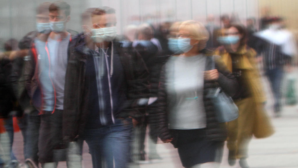 Passanten mit Mund und Nase Bedeckung spiegeln sich in einer Schaufensterscheibe in der Einkaufsstraße und Fußgängerzone Neuhauser Straße Kaufingerstraße in der Innenstadt von München, Bayern, Deutschland *** Passers-by with mouth and nose cover are