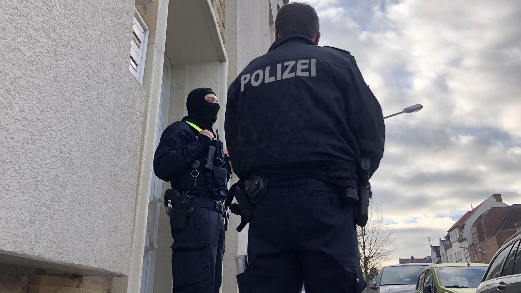 06.11.2020, Niedersachsen, Osnabrück: Polizisten stehen im Rahmen einer Durchsuchung vor einem Wohnhaus. Nach dem islamistischen Terroranschlag von Wien haben Ermittler am Freitagmorgen die Wohnungen von vier jungen Männern in Deutschland durchsucht.