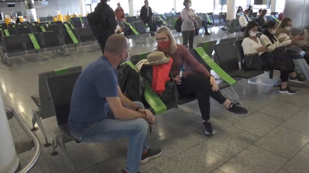 Mann und Frau an Gate auf Sitzplätzen