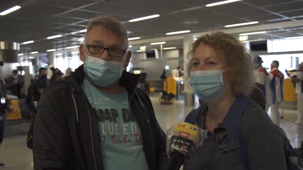 Mann und Frau mit Maske am Gate