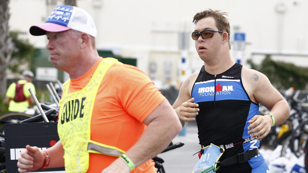 HANDOUT - 07.11.2020, USA, Panama City Beach: Chris Nikic (r) läuft neben seinem Trainer und Guide Dan Grieb, mit dem er mit einem Gurt verbunden ist, beim Ironman 2020. Nach Angaben der Veranstalter hat der 21 Jahre alte Amerikaner als erster Sportl