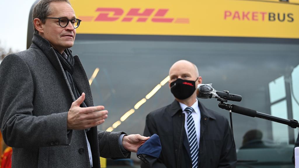 Michael Müller (SPD, l), Berlins Regierender Bürgermeister, und Michael Heimbokel, Geschäftsbereichsleiter Betrieb Ost bei der Deutschen Post DHL, nehmen an der Vorstellung der DHL-Paketbusse für Berlin teil.
