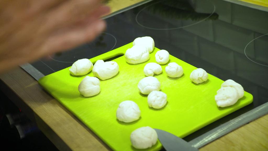 Dosen-Brötchenteig in Kugeln auf einem Küchenbrett