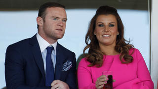 LIVERPOOL, ENGLAND - APRIL 12:  Manchester United football player Wayne Rooney and his wife Coleen watch the racing during the first day of the Aintree Grand National meeting on April 12, 2012 in Aintree, England. The first day, known as Liverpool Day, celebrates the city's link with the famous Aintree Racecourse.  (Photo by Christopher Furlong/Getty Images)