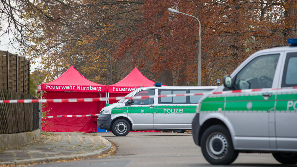 21.11.2020, Bayern, Nürnberg: Polizisten bewachen die Zufahrt einer Straße, in der zuvor zwei Menschen erschossen wurden. Wie eine Polizeisprecherin sagte, wurde ein Tatverdächtiger festgenommen. Hinweise auf einen terroristischen Hintergrund lägen n
