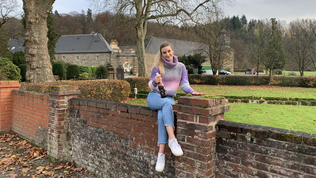 Daria Bücheler sitzt auf einer Mauer vor dem Soap-Schloss "Königsbrunn".