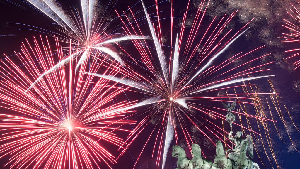 ARCHIV - 01.01.2018, Berlin: Ein Feuerwerk ist bei Deutschlands größter Silvesterparty hinter dem Brandenburger Tor zu sehen. (Zu dpa "Knapp zwei Drittel für Verbot von Silvesterfeuerwerk in diesem Jahr") Foto: Ralf Hirschberger/dpa +++ dpa-Bildfunk