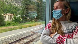 Frau mit Maske im Zug