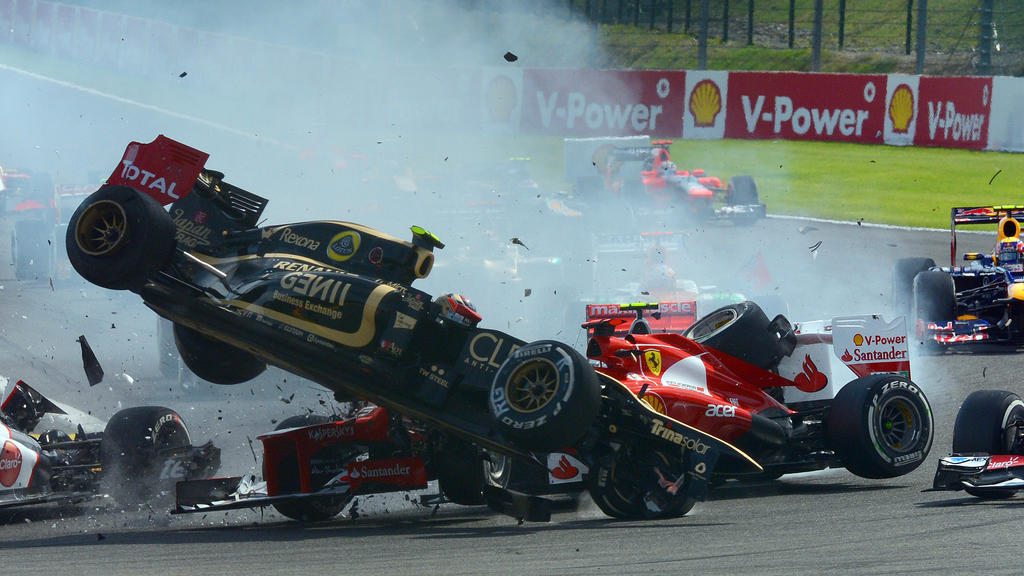 Romain Grosjean fliegt in Spa über Fernando Alonso im Ferrari.