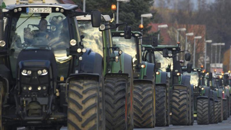Landwirte fahren mit Traktoren auf einer Landstraße. Foto: Robert Michael/dpa-Zentralbild/dpa/Aktuell